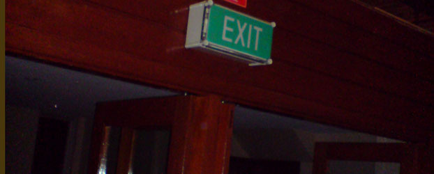 If there were an emergency, the lights might go out. There might be smoke and panic. This exit sign was not illuminated. This was at the front of the hall.